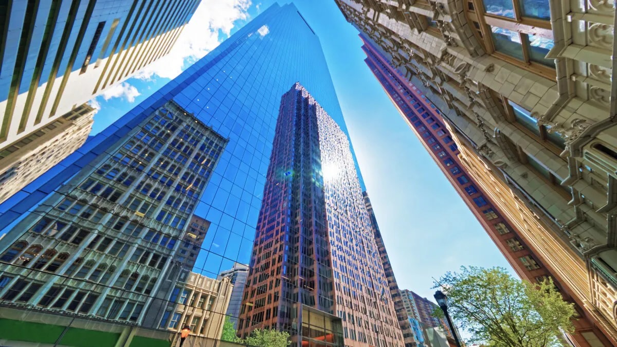 Looking up at tall commercial real estate buildings from the ground level