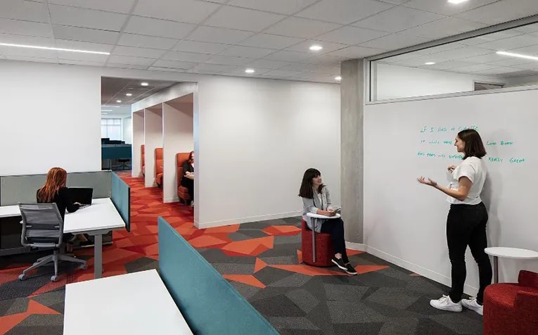 Cerity's Austin office, designed by Abel Design Group, makes clever use of space with white board walls, mobile lounge chairs and built-in booth seating in the hallway. (Tre Dunham)