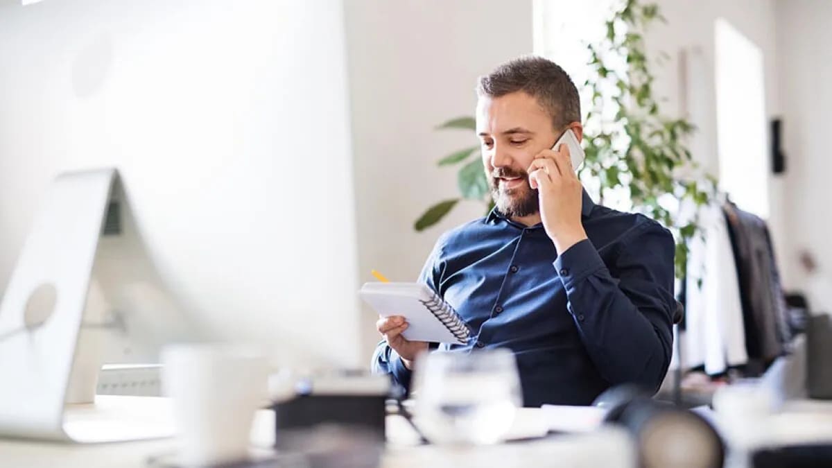 Businessman making a phone call sitting at a desk