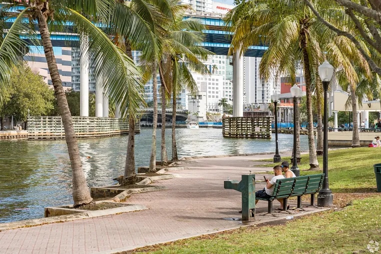 People sitting on a bench in Jose Marti park in the Riverside neighborhood of Miami, FL.