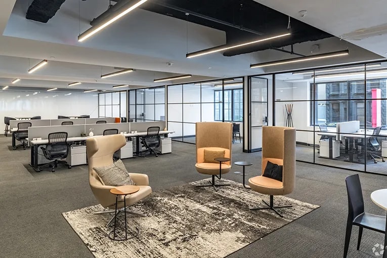 Coworking space lounge area with working desk space in the background