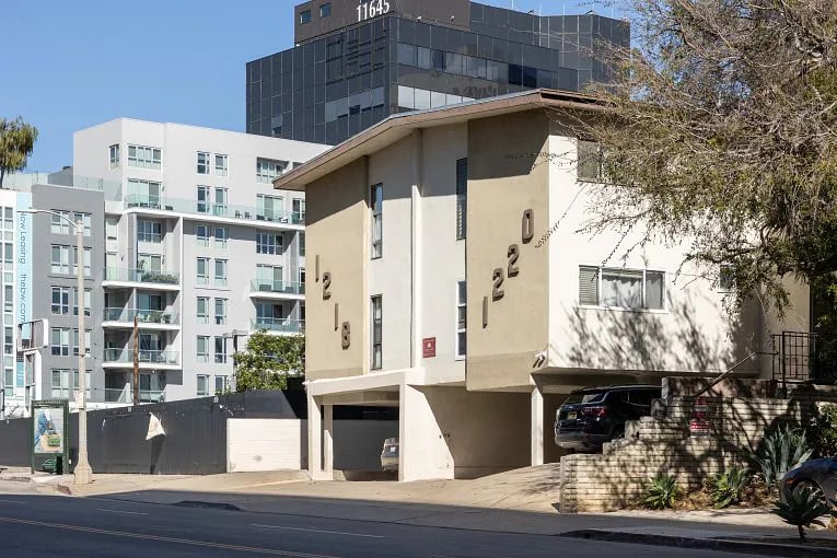 White and cream colored Dingbat style apartment building exterior view in Los Angeles, CA