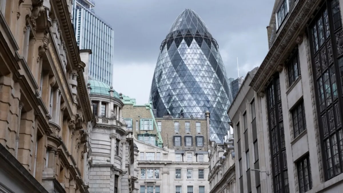 30 St Mark Axe, affectionately nicknamed the Gherkin, contrasts against old buildings in the City of London.