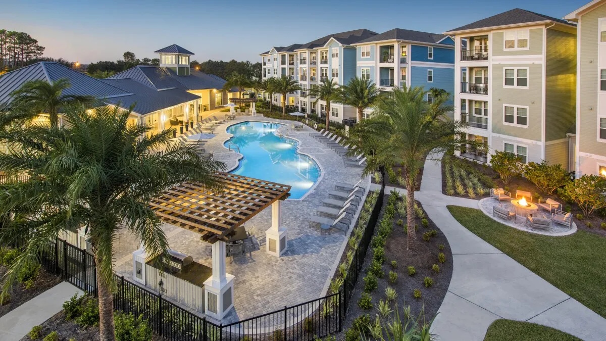 Multifamily property with a pool and palm trees - Point at Tamaya in Jacksonville, Florida