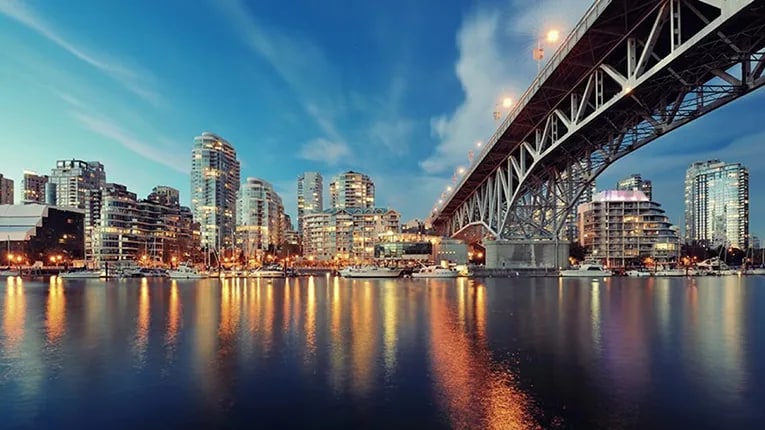 Cityscape with a lake in the foreground and a bridge on the right side