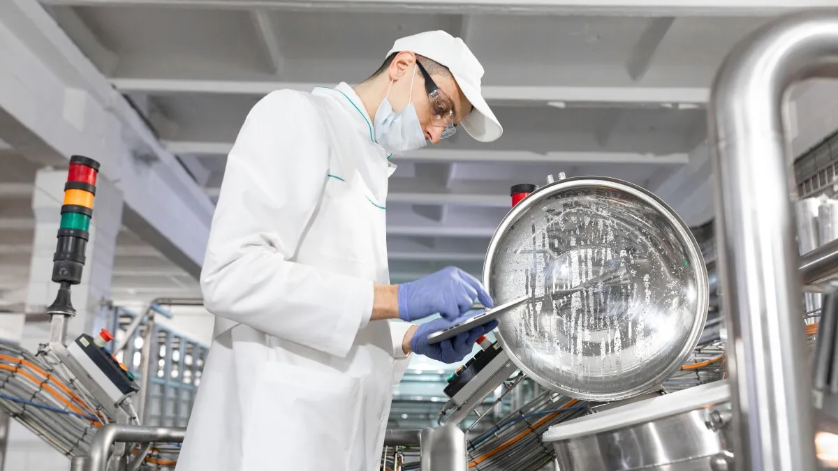 Employee dressed in white working in a food processing facility