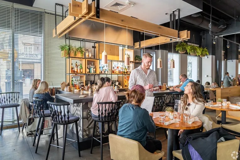 Interior view of a waiter and diners at a restaurant in Austin, TX.