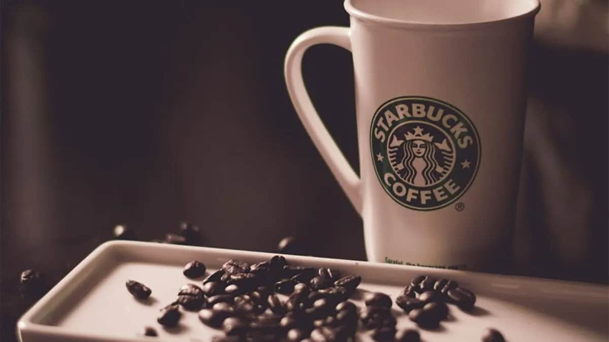 Starbucks coffee cup with coffee beans in the foreground