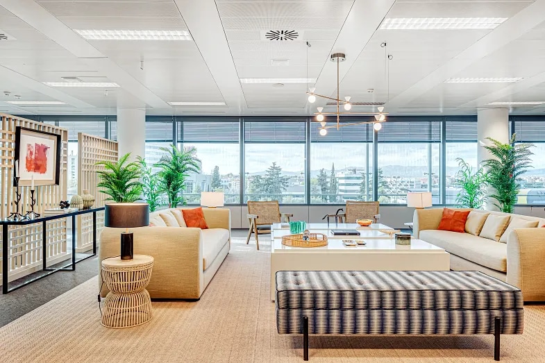 Interior view of an office's reception and waiting area with furniture, lamps and room divider